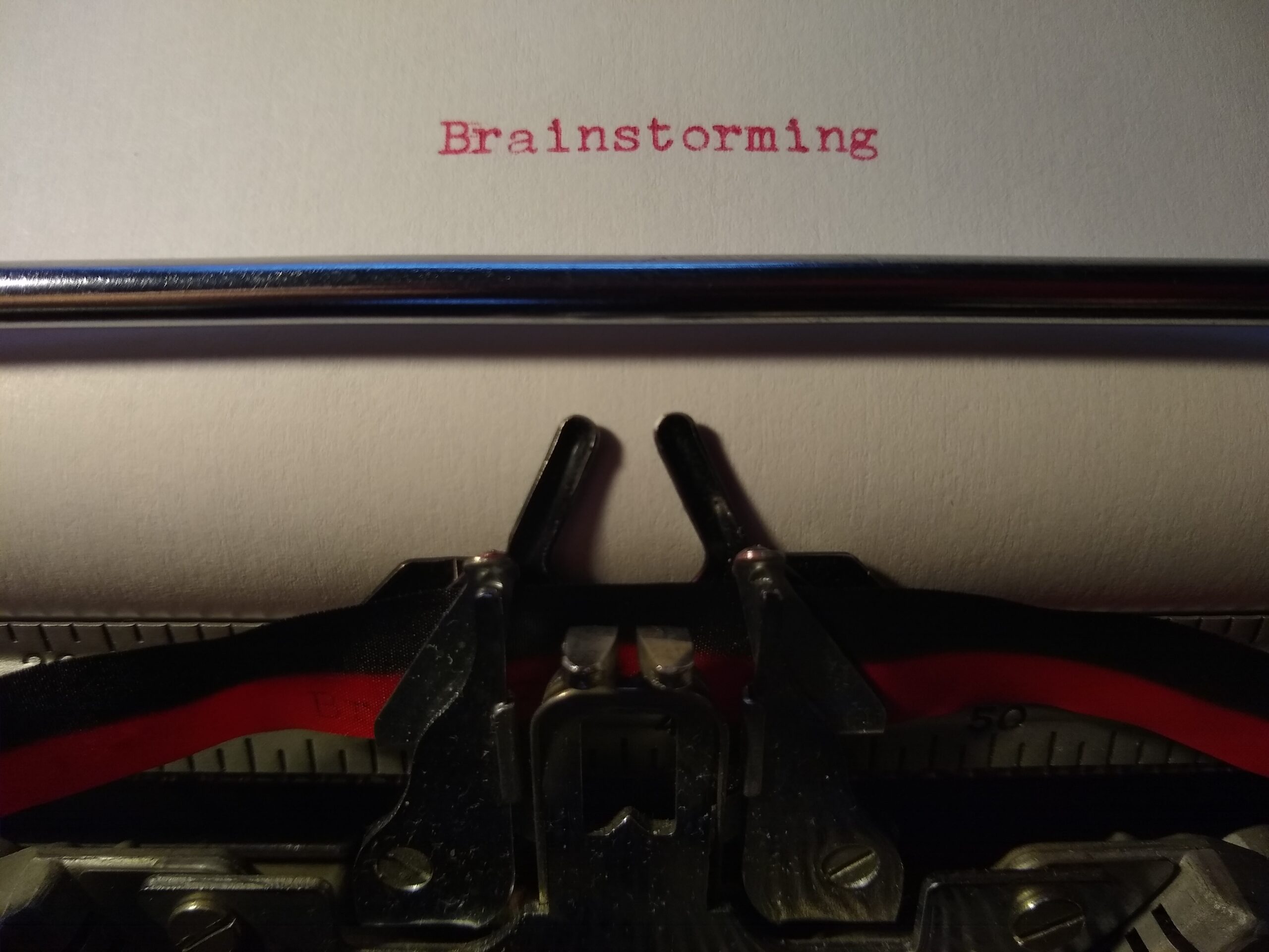 typewritten word "Brainstorming" on white paper in red ink